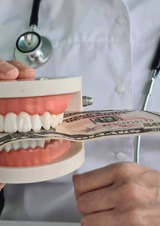 Dentist holding mouth mold with money